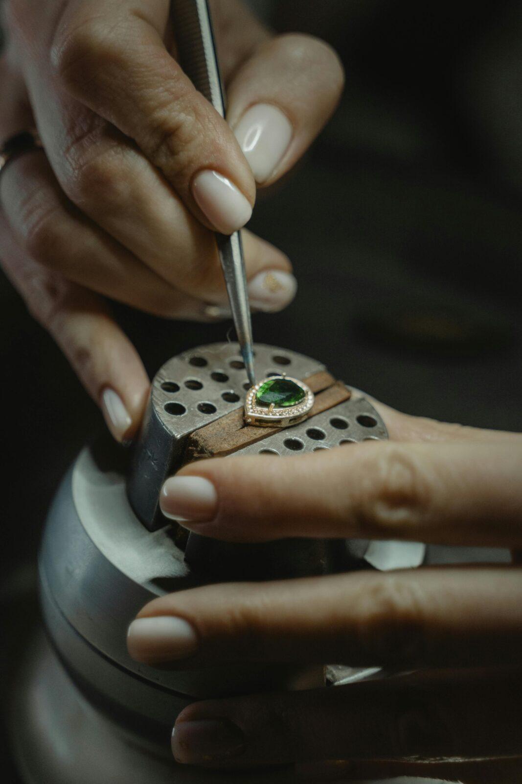 pexels-photo-6263143-6263143 A skilled jeweler carefully crafting an emerald ring using a tweezer, showcasing craftsmanship.
